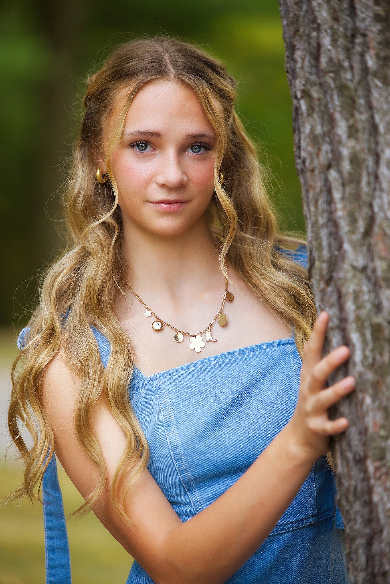 Senior portrait — girl leaning against tree in denim